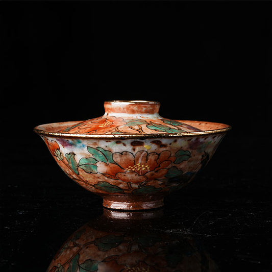 A traditional Chinese ceramic gaiwan with a lid, adorned with colorful floral and bird motifs. It features a golden rim, intricate hand-painted designs, and a glossy finish, embodying classic Chinese porcelain art. Ideal for tea ceremonies, this decorative piece showcases cultural heritage and fine craftsmanship. Perfect for collectors of Asian ceramics, highlighting vibrant colors and traditional aesthetics.