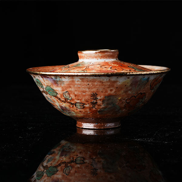 A traditional Chinese ceramic gaiwan with a lid, adorned with colorful floral and bird motifs. It features a golden rim, intricate hand-painted designs, and a glossy finish, embodying classic Chinese porcelain art. Ideal for tea ceremonies, this decorative piece showcases cultural heritage and fine craftsmanship. Perfect for collectors of Asian ceramics, highlighting vibrant colors and traditional aesthetics.