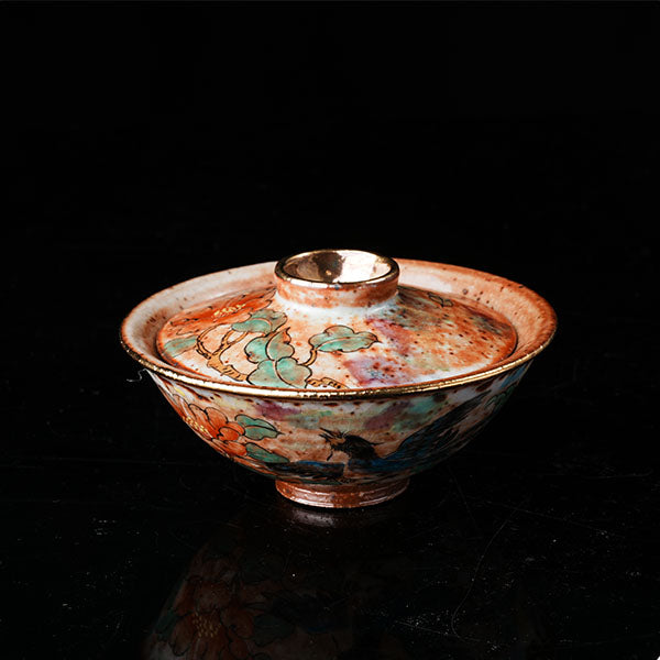 A traditional Chinese ceramic gaiwan with a lid, adorned with colorful floral and bird motifs. It features a golden rim, intricate hand-painted designs, and a glossy finish, embodying classic Chinese porcelain art. Ideal for tea ceremonies, this decorative piece showcases cultural heritage and fine craftsmanship. Perfect for collectors of Asian ceramics, highlighting vibrant colors and traditional aesthetics.