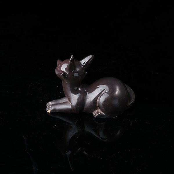 Fox Tea Pet - A beautifully crafted, dark - colored ceramic figurine of a fox, exuding charm and elegance. With a sleek and polished surface, it captures the grace of a fox in a resting pose. Ideal for tea enthusiasts, this tea pet can enhance the tea - brewing ritual. Handmade with attention to detail, it's a perfect addition to any tea collection, symbolizing wisdom and allure in many cultures.