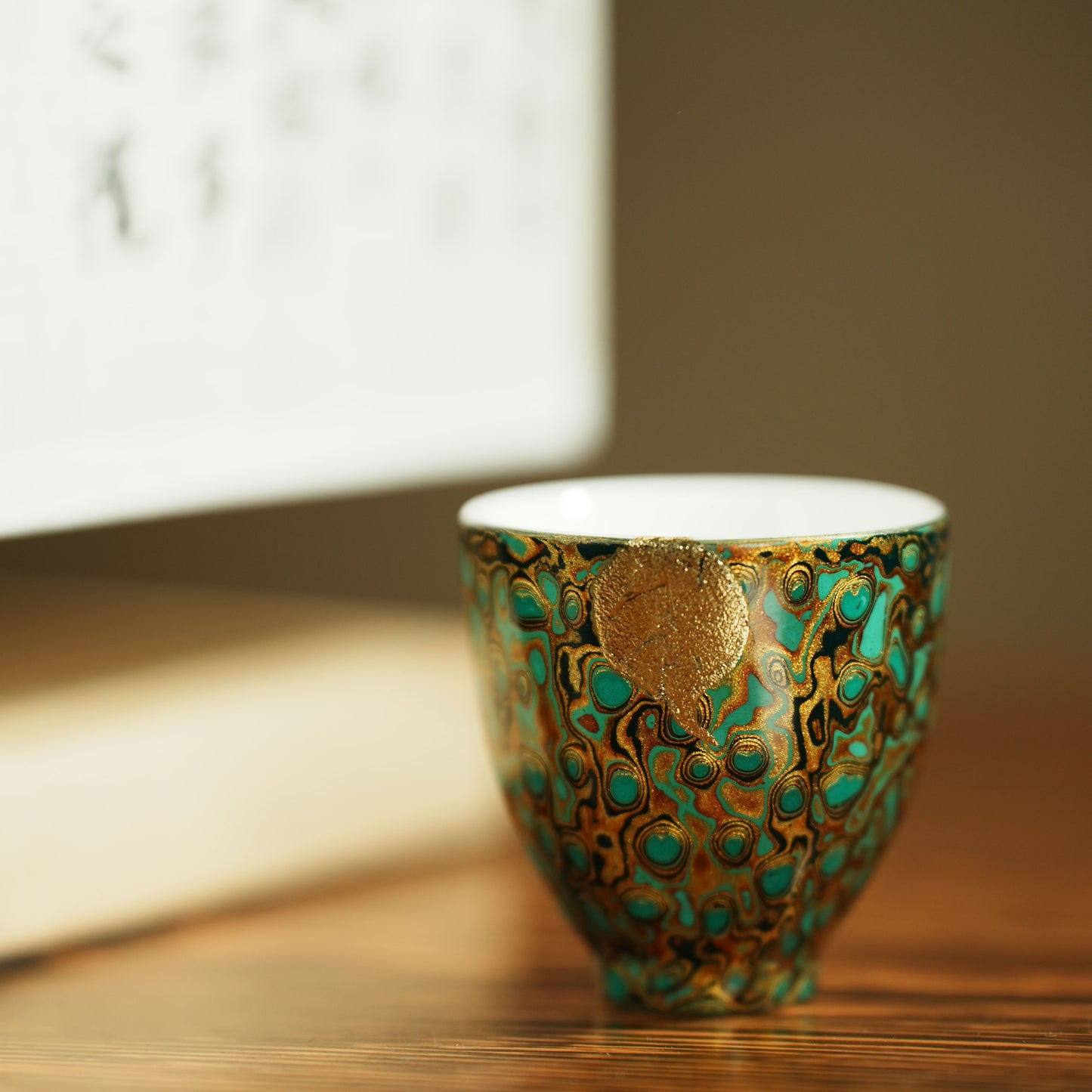 Host cup with a green peacock feather pattern as the background color and gold texture.