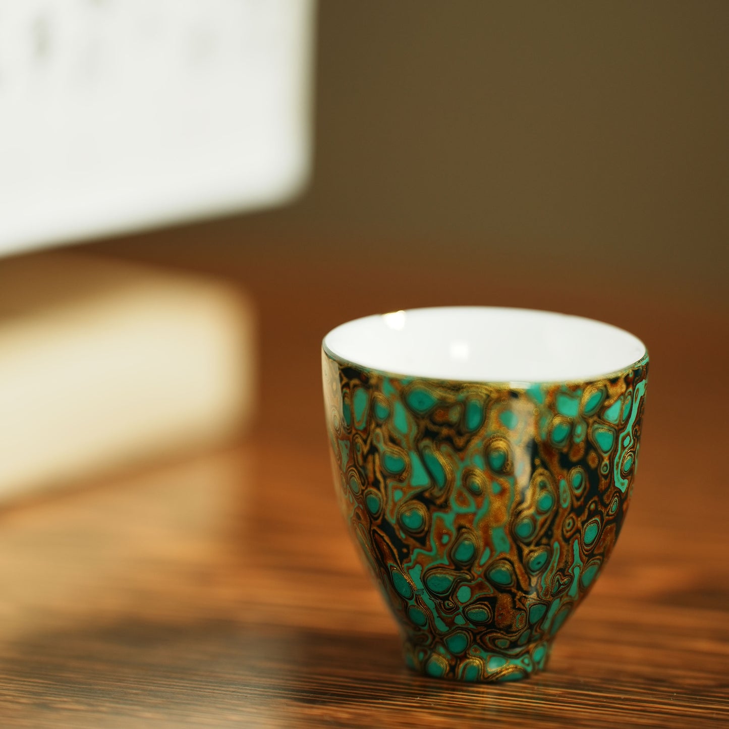 Host cup with a green peacock feather pattern as the background color and gold texture.