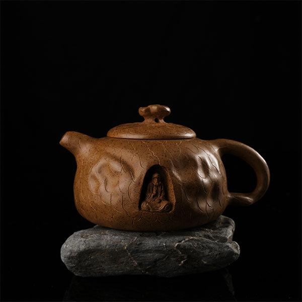This is Gulong Klin Bodhidharma Gongchun Purple Clay Teapot, Handcrafted Zen-inspired teapot for tea rituals.The purple clay teapot is mainly khaki in color, and a Bodhidharma figure is engraved on the outer wall.