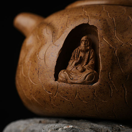 This is Gulong Klin Bodhidharma Gongchun Purple Clay Teapot, Handcrafted Zen-inspired teapot for tea rituals.The purple clay teapot is mainly khaki in color, and a Bodhidharma figure is engraved on the outer wall.