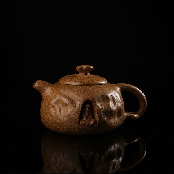 This is Gulong Klin Bodhidharma Gongchun Purple Clay Teapot, Handcrafted Zen-inspired teapot for tea rituals.The purple clay teapot is mainly khaki in color, and a Bodhidharma figure is engraved on the outer wall.