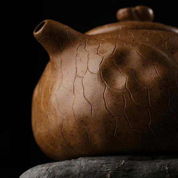 This is Gulong Klin Bodhidharma Gongchun Purple Clay Teapot, Handcrafted Zen-inspired teapot for tea rituals.The purple clay teapot is mainly khaki in color, and a Bodhidharma figure is engraved on the outer wall.