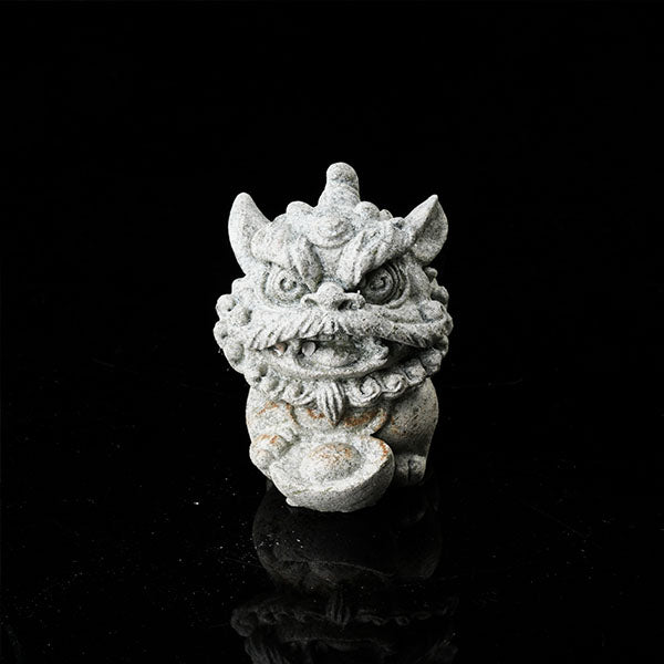 This is a lion dance tea pet holding a gold ingot.