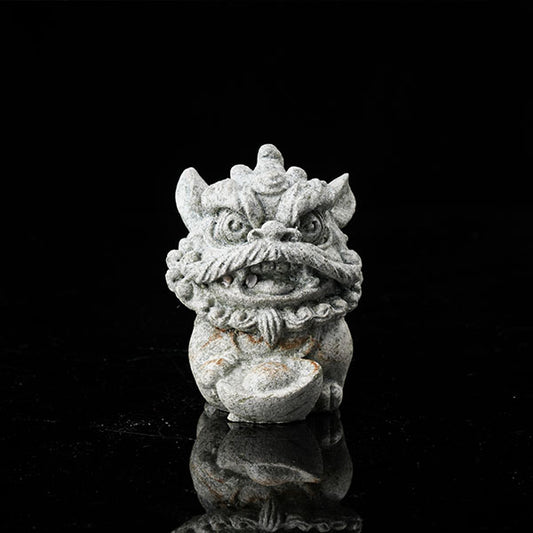 This is a lion dance tea pet holding a gold ingot.