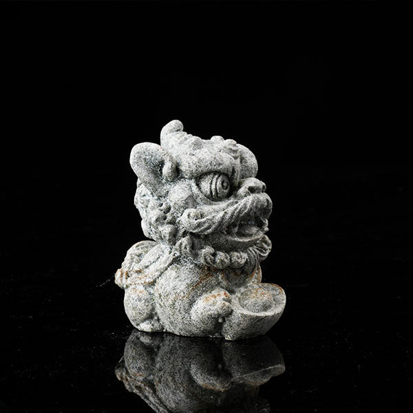 This is a lion dance tea pet holding a gold ingot.