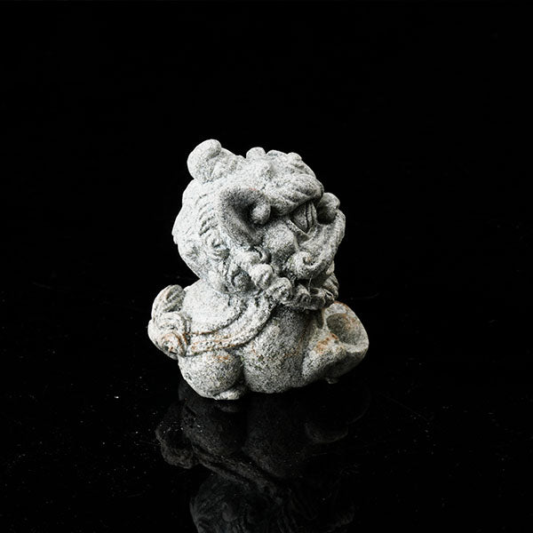This is a lion dance tea pet holding a gold ingot.