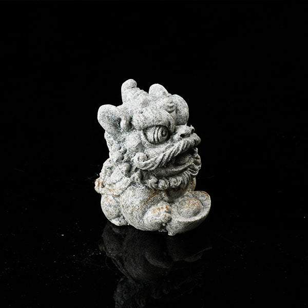 This is a lion dance tea pet holding a gold ingot.