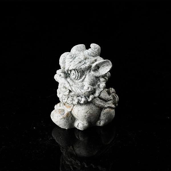This is a lion dance tea pet holding a gold ingot.