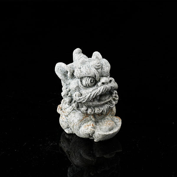 This is a lion dance tea pet holding a gold ingot.