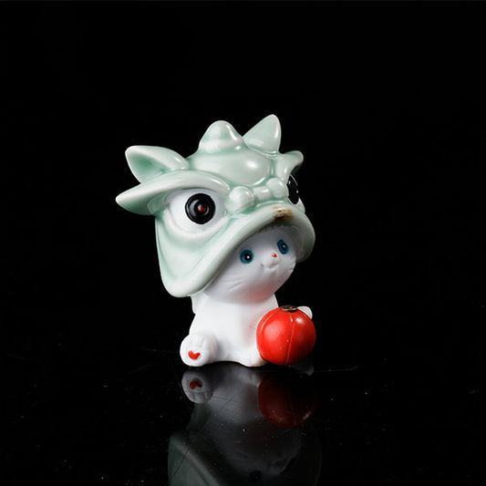 This is a lucky cat tea pet wearing a lion dance hat.