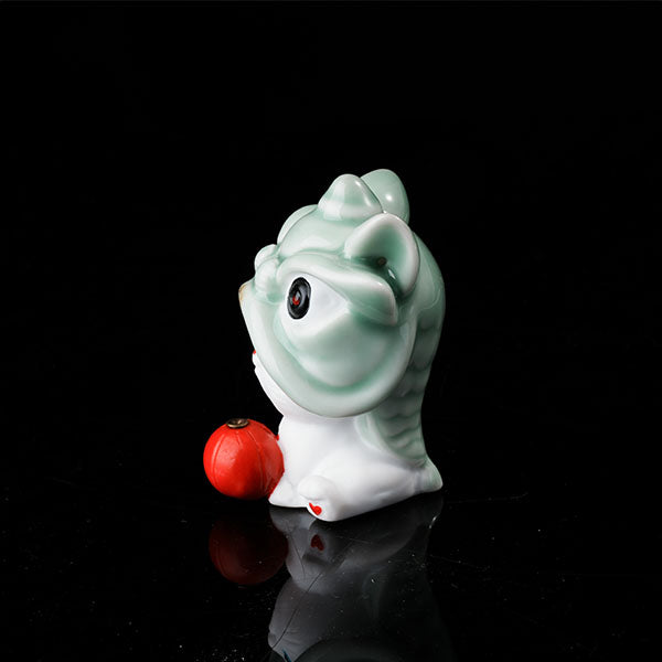 This is a lucky cat tea pet wearing a lion dance hat.