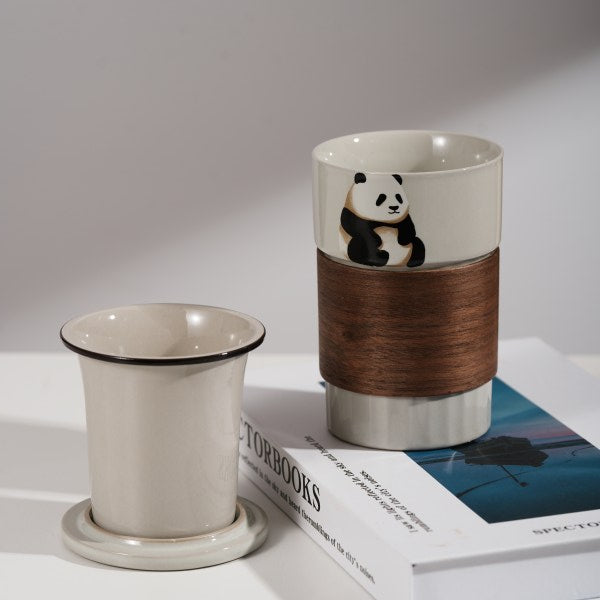 This is a branded teacup with accessories including a teacup with a lid and a filter pot in the teacup. The brand is Jade Peak Reserve. There is a wooden anti-scalding plate on one side of the cup and a cute panda on the other side.