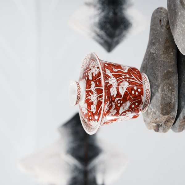 This is a red-bottomed Gaiwan with white patterns, depicting a egret playing among lotus leaves. The theme is "One egret wins the first prize", which means the blessing for students who win the college entrance examination in ancient China.
