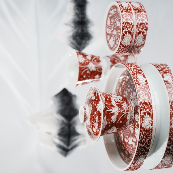 This is a red-bottomed Gaiwan with white patterns, depicting a egret playing among lotus leaves. The theme is "One egret wins the first prize", which means the blessing for students who win the college entrance examination in ancient China.