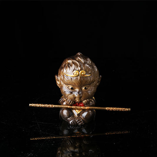 This is the Son Wukong tea pet sitting cross-legged on the ground, holding the golden hoop stick.