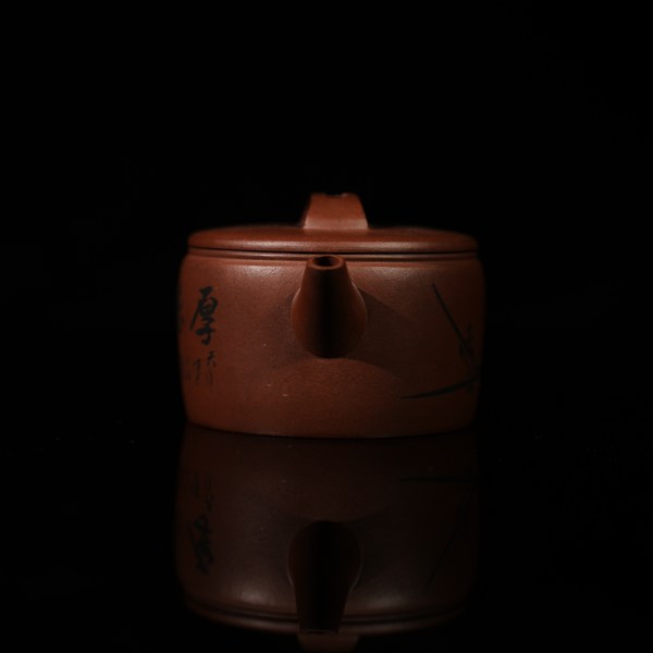 This is a handmade Yixing purple clay teapot, made by Master Chen Xiaozhong. There are bamboo leaves carved on the left side of the teapot, and the four characters "Hou De Zai Wu" are written on the right side.