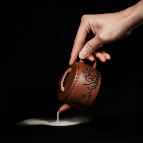This is a handmade Yixing purple clay teapot, made by Master Chen Xiaozhong. There are bamboo leaves carved on the left side of the teapot, and the four characters "Hou De Zai Wu" are written on the right side.