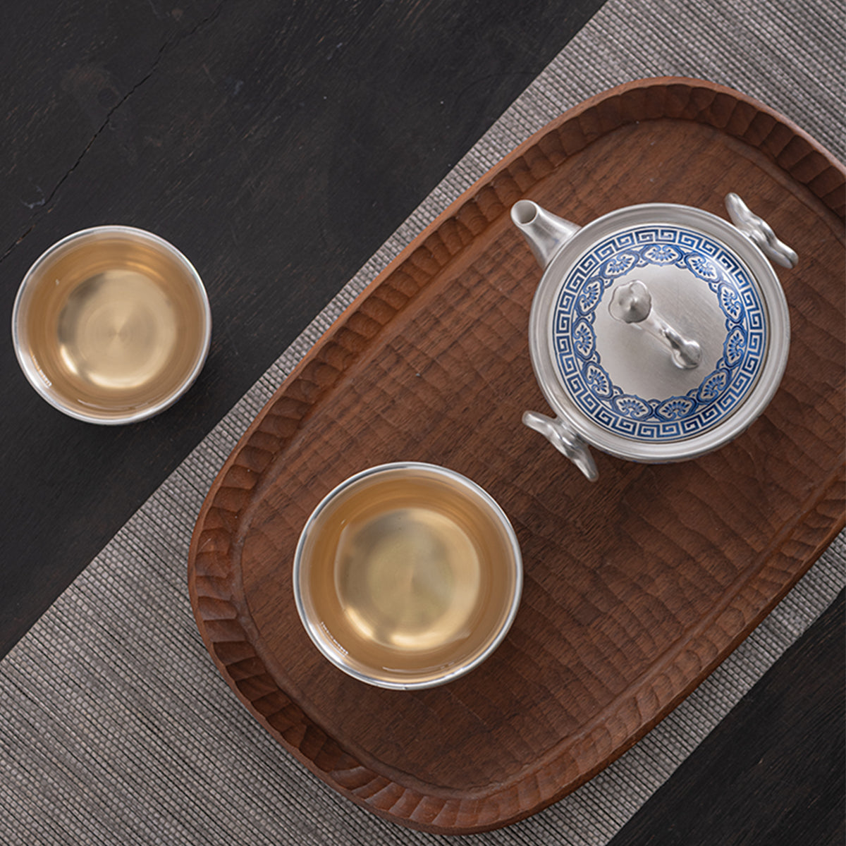 A silver-inlaid lotus-branch patterned teapot with two cups. Chaliland