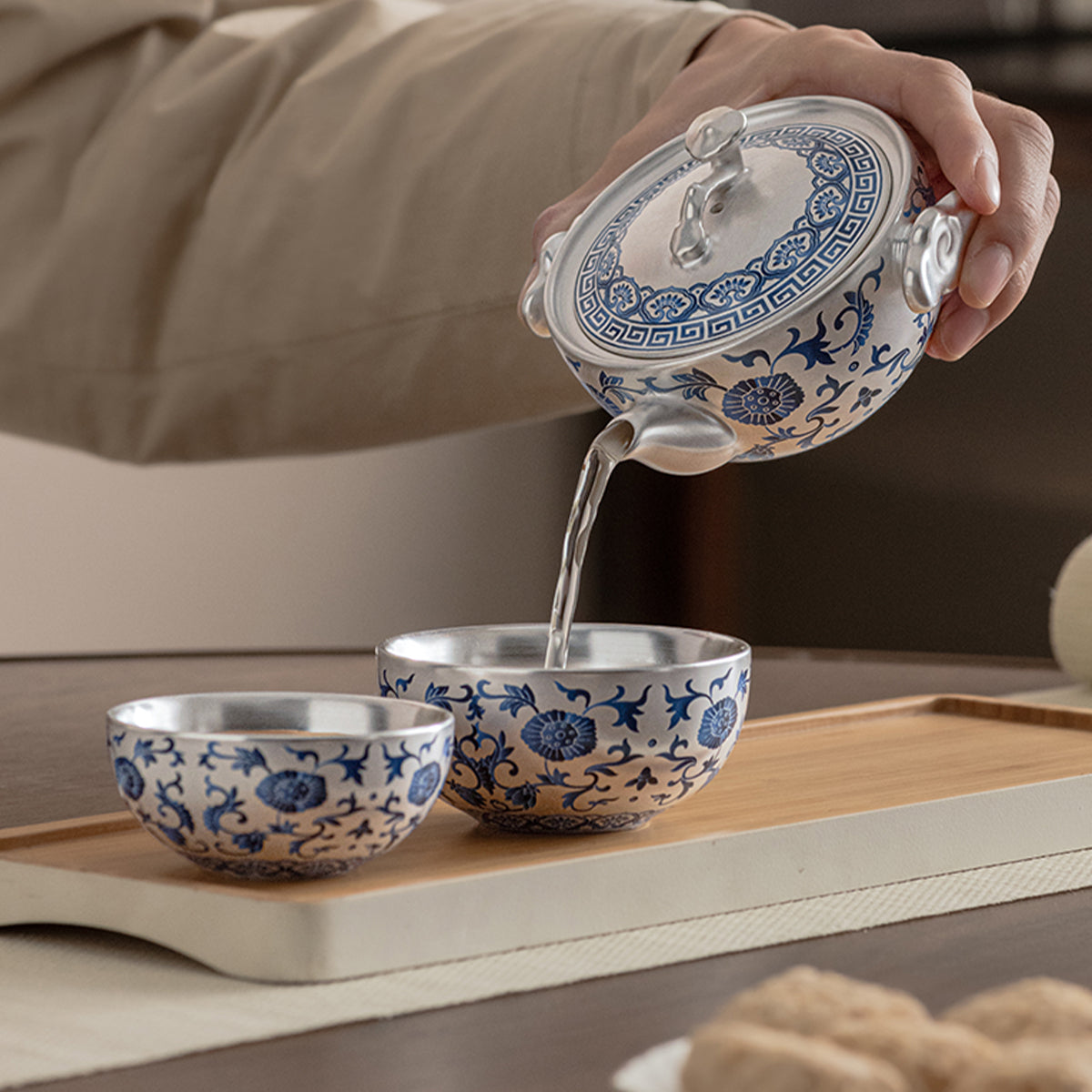 A silver-inlaid lotus-branch patterned teapot with two cups. Chaliland