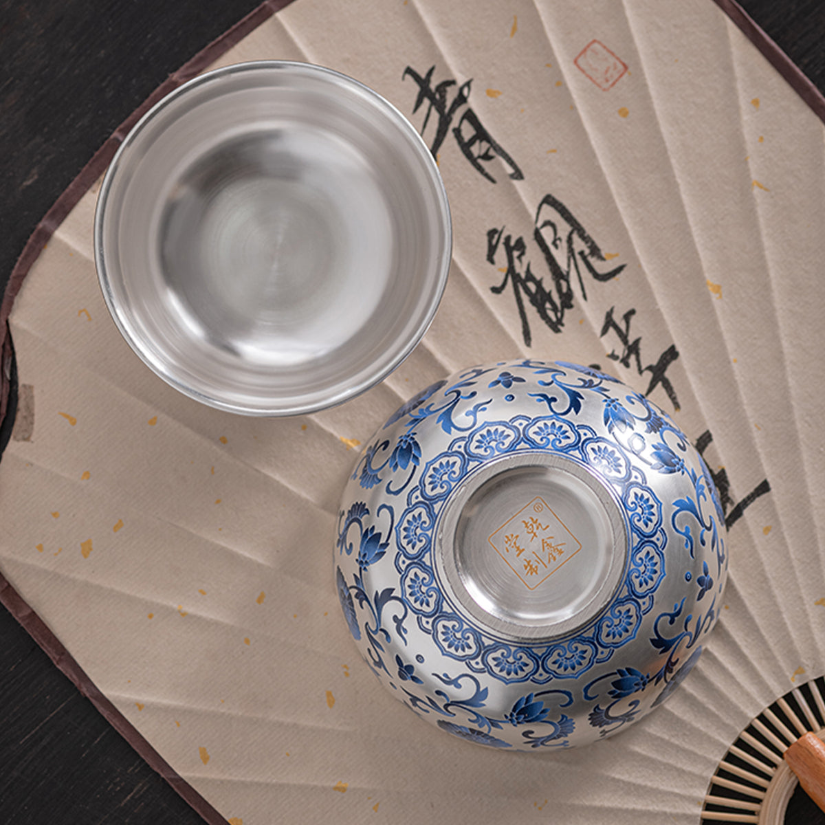 A silver-inlaid lotus-branch patterned teapot with two cups. Chaliland