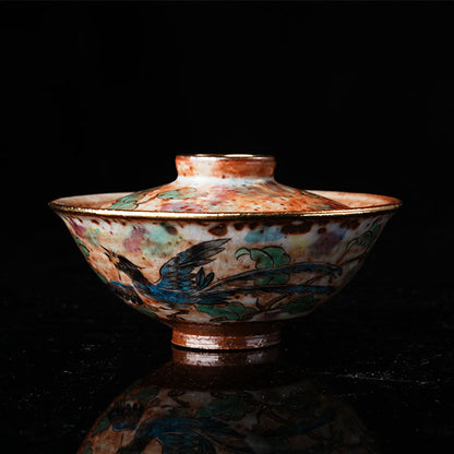 A traditional Chinese ceramic gaiwan with a lid, adorned with colorful floral and bird motifs. It features a golden rim, intricate hand-painted designs, and a glossy finish, embodying classic Chinese porcelain art. Ideal for tea ceremonies, this decorative piece showcases cultural heritage and fine craftsmanship. Perfect for collectors of Asian ceramics, highlighting vibrant colors and traditional aesthetics.