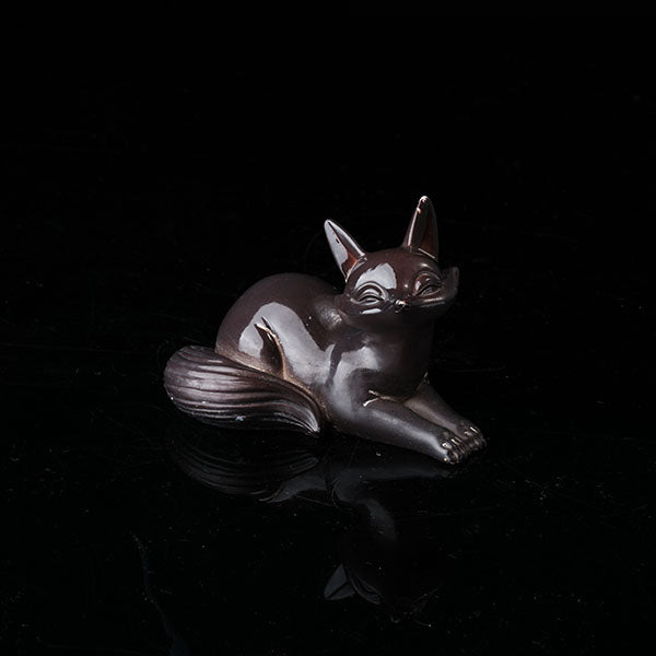 Fox Tea Pet - A beautifully crafted, dark - colored ceramic figurine of a fox, exuding charm and elegance. With a sleek and polished surface, it captures the grace of a fox in a resting pose. Ideal for tea enthusiasts, this tea pet can enhance the tea - brewing ritual. Handmade with attention to detail, it's a perfect addition to any tea collection, symbolizing wisdom and allure in many cultures.