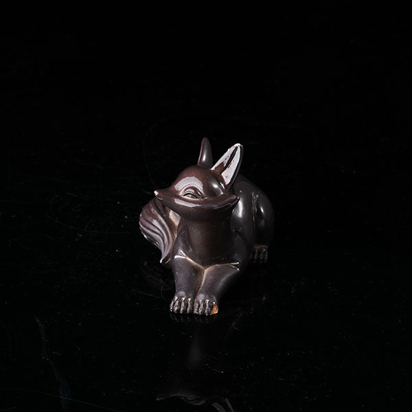 Fox Tea Pet - A beautifully crafted, dark - colored ceramic figurine of a fox, exuding charm and elegance. With a sleek and polished surface, it captures the grace of a fox in a resting pose. Ideal for tea enthusiasts, this tea pet can enhance the tea - brewing ritual. Handmade with attention to detail, it's a perfect addition to any tea collection, symbolizing wisdom and allure in many cultures.