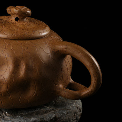 This is Gulong Klin Bodhidharma Gongchun Purple Clay Teapot, Handcrafted Zen-inspired teapot for tea rituals.The purple clay teapot is mainly khaki in color, and a Bodhidharma figure is engraved on the outer wall.