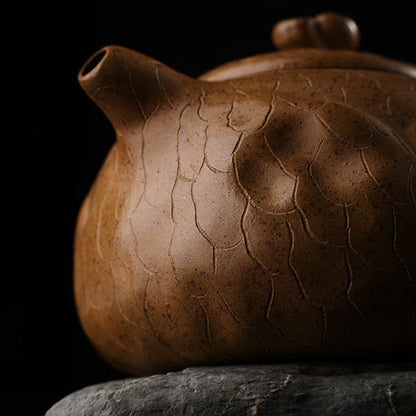 This is Gulong Klin Bodhidharma Gongchun Purple Clay Teapot, Handcrafted Zen-inspired teapot for tea rituals.The purple clay teapot is mainly khaki in color, and a Bodhidharma figure is engraved on the outer wall.