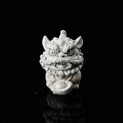 This is a lion dance tea pet holding a gold ingot.