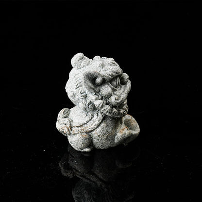 This is a lion dance tea pet holding a gold ingot.