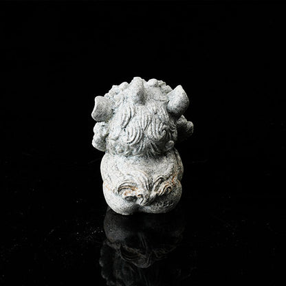 This is a lion dance tea pet holding a gold ingot.