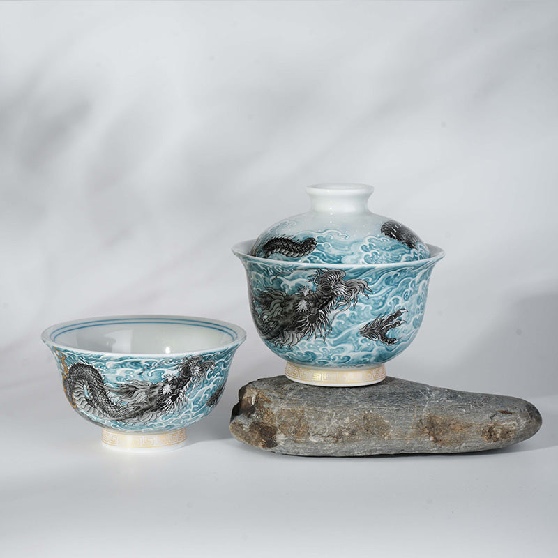 This showcases an exquisite blue and white gaiwan with a lifelike loong pattern. The bowl is placed on an irregular gray stone base with a light background, creating a classic and elegant atmosphere.