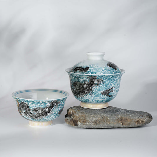 This showcases an exquisite blue and white gaiwan with a lifelike loong pattern. The bowl is placed on an irregular gray stone base with a light background, creating a classic and elegant atmosphere.