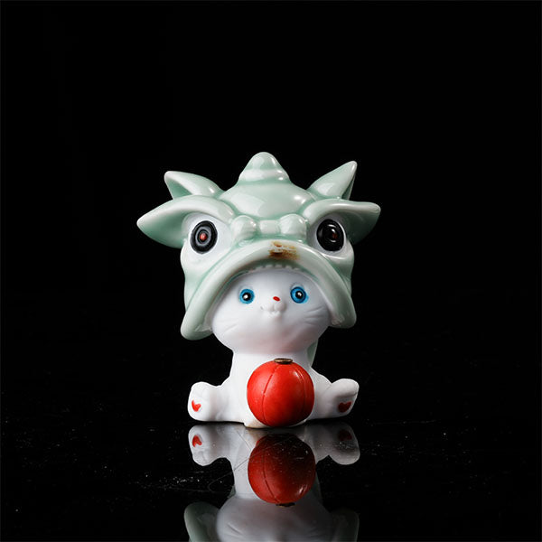 This is a lucky cat tea pet wearing a lion dance hat.