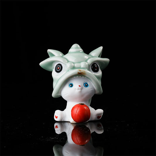 This is a lucky cat tea pet wearing a lion dance hat.