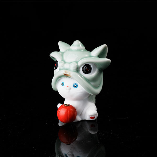 This is a lucky cat tea pet wearing a lion dance hat.