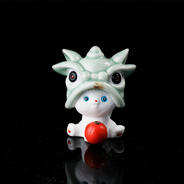 This is a lucky cat tea pet wearing a lion dance hat.