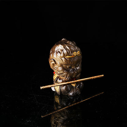 This is the Son Wukong tea pet sitting cross-legged on the ground, holding the golden hoop stick.