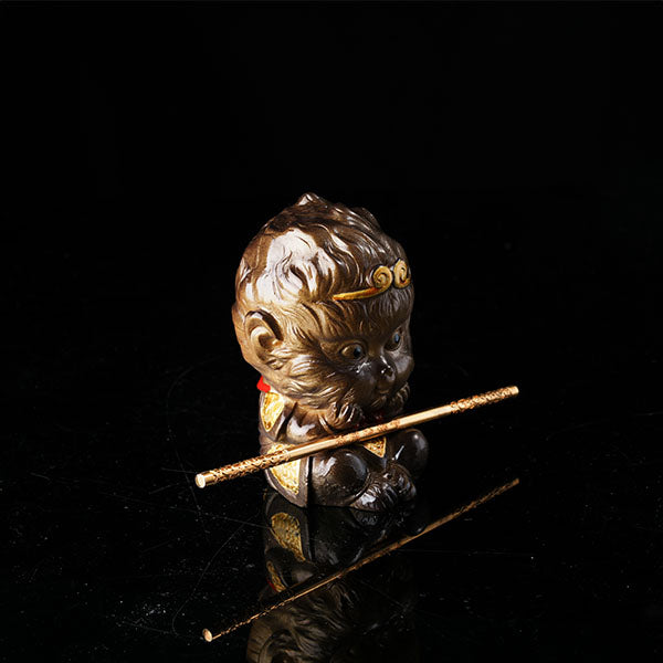 This is the Son Wukong tea pet sitting cross-legged on the ground, holding the golden hoop stick.