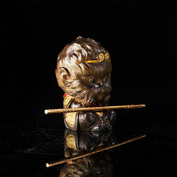 This is the Son Wukong tea pet sitting cross-legged on the ground, holding the golden hoop stick.