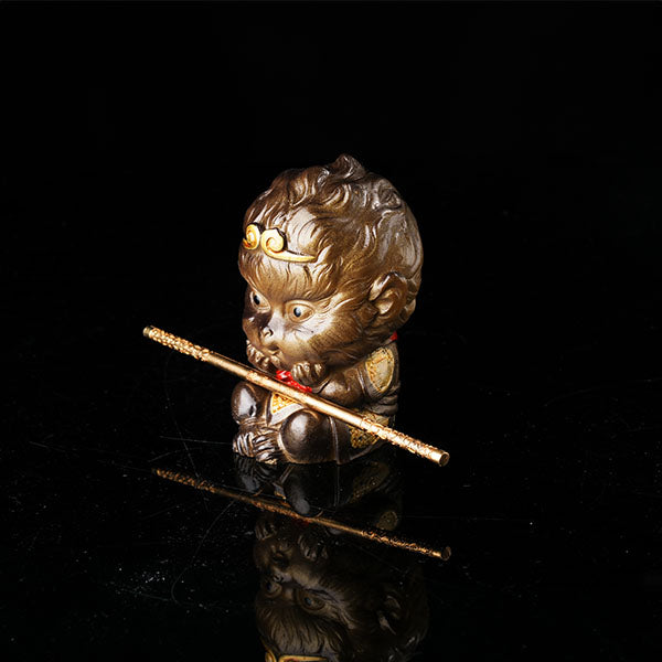 This is the Son Wukong tea pet sitting cross-legged on the ground, holding the golden hoop stick.