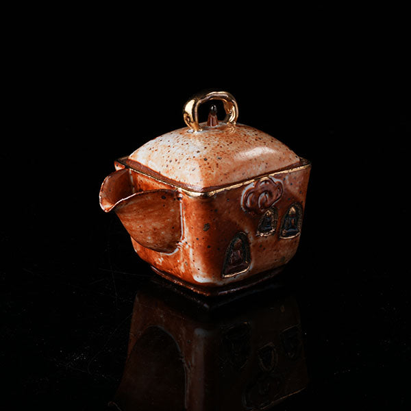 The Buddha without Form Square Teapot - Traditional ceramic teapot with square form, speckled brown glaze, gold handle, and relief figures (possibly Buddhist motifs). Handcrafted, rustic design, ideal for tea rituals. Features intricate detailing, cultural artistry, and functional elegance. Perfect for collectors of unique teaware, highlighting craftsmanship and traditional aesthetics.