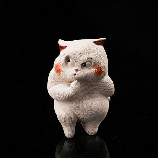 This is a cunning little cat tea pet, with a kitchen knife hidden in its left paw.