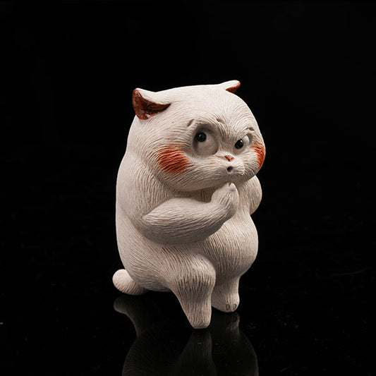 This is a cunning little cat tea pet, with a kitchen knife hidden in its left paw.