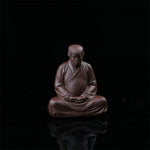 This is a purple clay tea pet with the image of Trump.